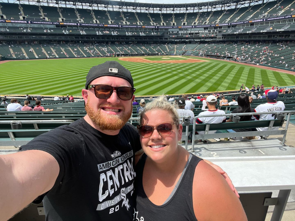 Drew and his wife taking a selfie with the ballpark behind them